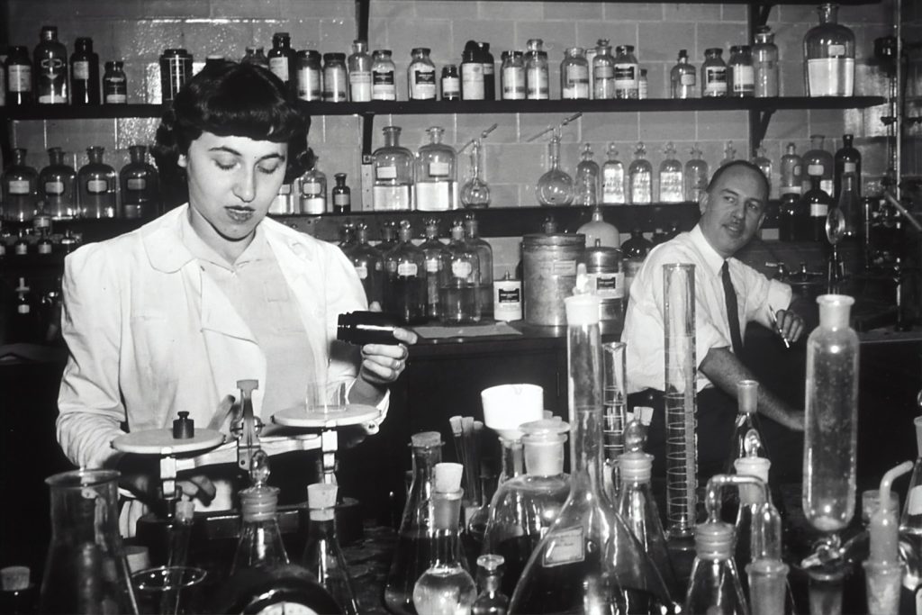grayscale photo of man and woman inside laboratory