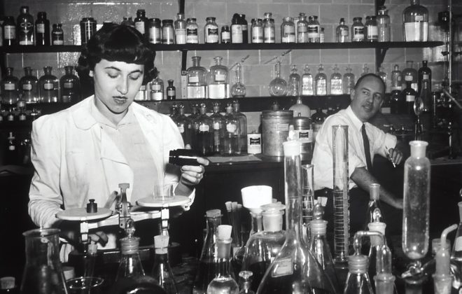 grayscale photo of man and woman inside laboratory